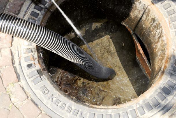 Vacuümwagen bij afvalput